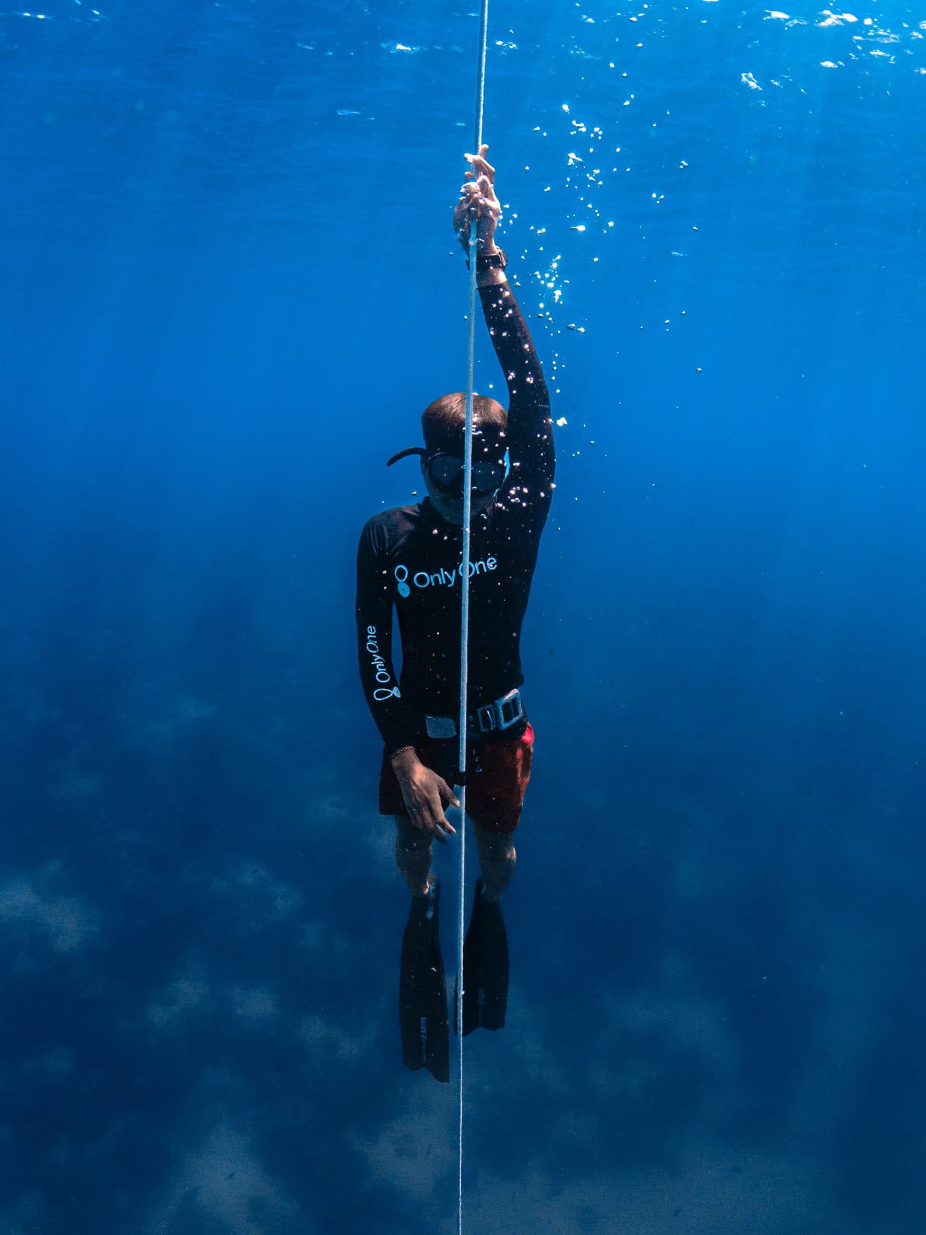 Freediver in the blue during a Wave 2 line training session in Bira